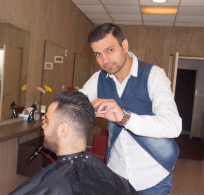 Barbier Omid van Moubiform Kapsalon knipt het haar van een klant, met volle aandacht voor de coupe